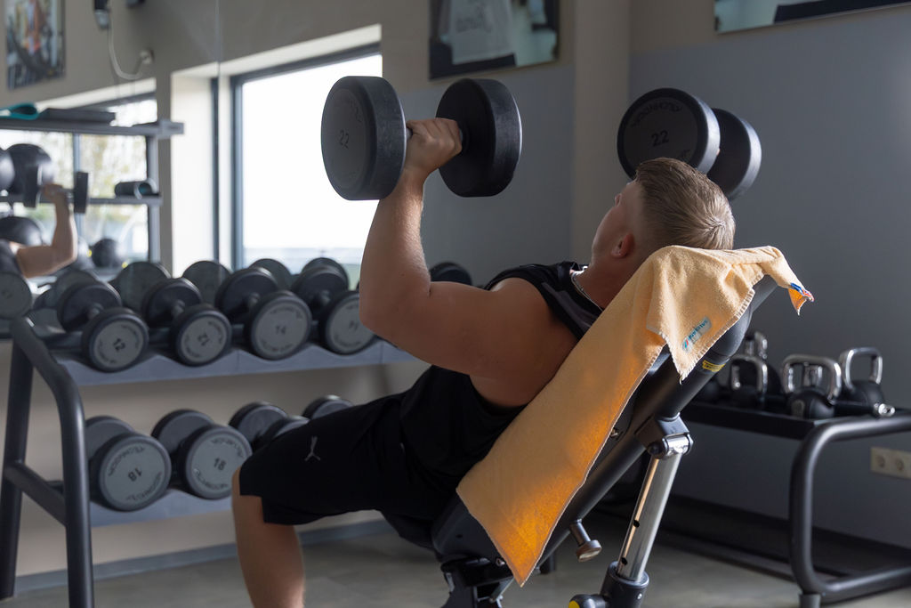 Mann beim Gewichtheben im Fitness Studio