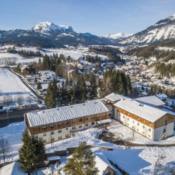 Sie sehen eine Außenansicht vom JUFA Hotel Bad Aussee*** aus der Vogelperspektive im Winter. JUFA Hotels bietet erholsamen Familienurlaub und einen unvergesslichen Winterurlaub.